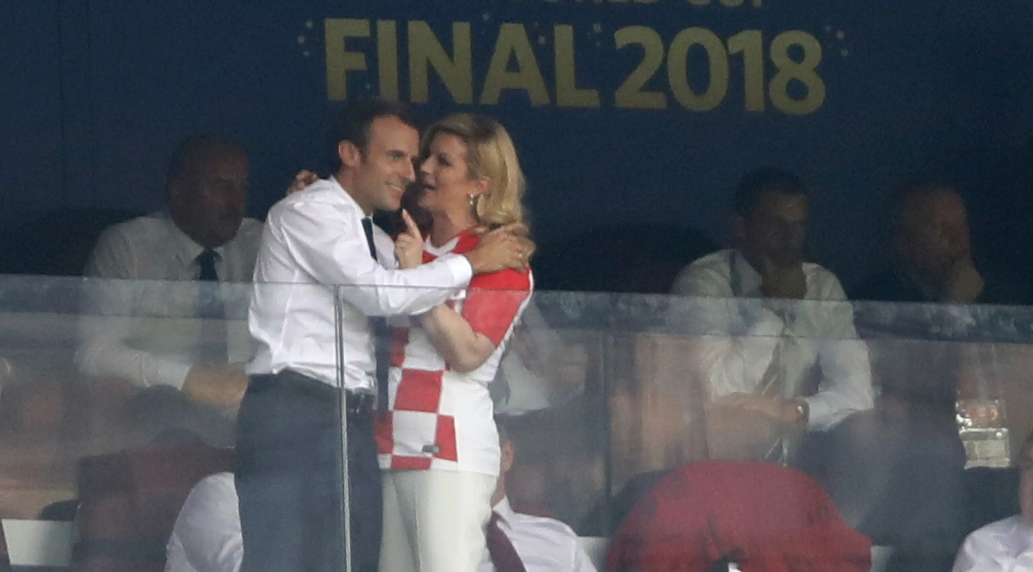 Presiden Kroasia Kolinda Grabar-Kitarovic (kanan) berbicara kepada Presiden Prancis Emmanuel Macron (kiri) selama pertandingan final Piala Dunia 2018 antara Prancis dan Kroasia di Stadion Luzhnik, Moskow, Rusia, Minggu (15/7). (AP Photo/Natacha Pisarenko)