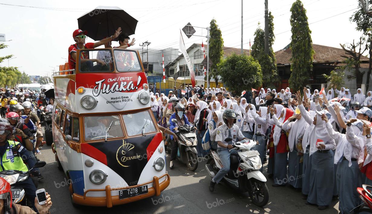 Ribuan siswa sekolah dan warga Kudus menyambut peraih emas bulutangkis Olimpiade Rio 2016, Tontowi Ahmad dan Liliyana Natsir, saat kirab melewati jalan-jalan utama kota Kudus, Kamis (1/9/2016). (Bola.com/Arief Bagus)