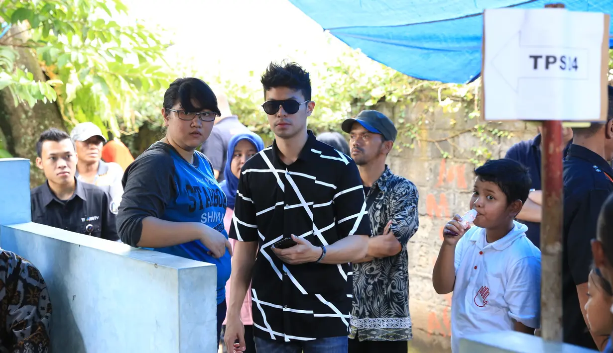 Bersama dengan ayahnya, Fero Walandouw berangkat dari kediamannya, Pondok Pinang, Jakarta Selatan. Sekitar pukul 10.00 WIB ia berangkat menuju Tempat Pemungutan Suara (TPS) yang berlokasi di Ciganjur. (Adrian Putra/Bintang.com)