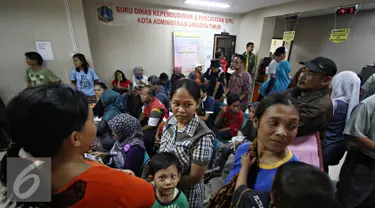 Warga menunggu untuk mendaftarkan akte kelahiran di Sudin Kependudukan dan Catatan Sipil Kotamadya, Jakarta Timur, Senin (28/12). Meskipun antre, namun ratusan warga tetap antusias mendaftarkan akte kelahiran serta e-KTP. (Liputan6.com/Immnuel Antonius) 