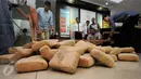 Petugas Dir IV Narkoba Mabes Polri membongkar puluhan pak ganja saat rilis di Jakarta, Selasa (24/5/2016). Petugas menahan enam orang tersangka dengan barang bukti narkoba jenis ganja seberat satu ton. (Liputan6.com/Helmi Fithriansyah)