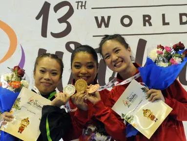 Atlet Wushu Indonesia, Juwita Niza WA (tengah) dan Ivana Ardelia (kanan) di podium kemenangan kelas Taulo Womens Nangun Kejuaraan Dunia Wushu ke-13 di Istora Senayan Jakarta, Selasa (17/11/2015). (Liputan6.com/Helmi Fithriansyah)