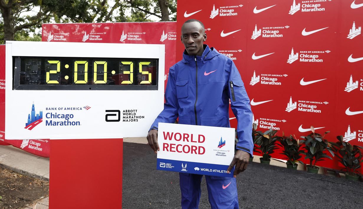 Pelari Kenya, Kelvin Kiptum berfoto bersama catatan waktunya di Chicago Marathon 2023 di Chicago, Illinois, Amerika Serikat, 8 Oktober 2023. Ia memecahkan rekor sebagai pelari marathon tercepat di dunia dengan mencatatkan waktu 2 jam 35 detik. (AFP/Kamil Krzaczynski)