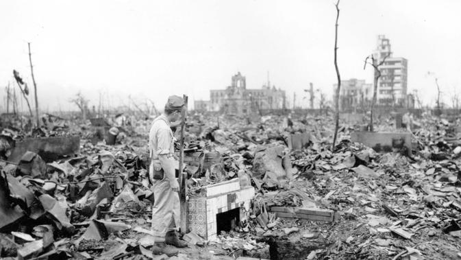 file foto 7 September 1945 ini, seorang pria tak dikenal berdiri di samping perapian berlantai tempat sebuah rumah pernah berdiri di Hiroshima, Jepang bagian barat. Pengeboman 6 Agustus 1945 adalah serangan nuklir pertama di dunia.(AP Photo/Stanley Troutman)
