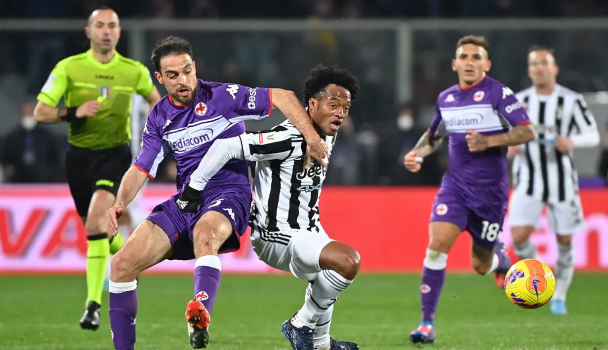 Pemain Juventus Juan Cuadrado (kanan) berebut bola dengan pemain Fiorentina Giacomo Bonaventura pada pertandingan sepak bola leg pertama semifinal Coppa Italia di Stadion Artemio-Franchi, Florence, Italia, 2 Maret 2022. Juventus menang 1-0. (Alberto PIZZOLI/AFP)