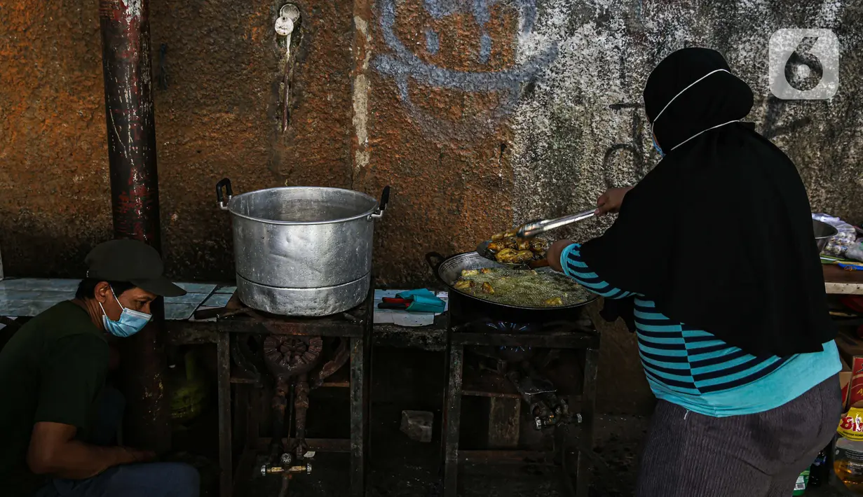 Warga memasak makanan untuk dibagikan di zona merah covid-19 Kelurahan Petogogan RT 006 RW 003, Jakarta, Selasa (22/6/2021). Dapur umum itu menyuplai kebutuhan makanan berat serta minuman untuk warga yang menjalani isolasi dan terdampak akibat COVID-19. (Liputann6.com/Faizal Fanani)