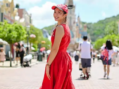 Dalam momen liburan bersama Podkesmas itu, Tyara Renata tampil menawan dengan sleveeless dress merah menyala. Berjalan menyusuri berbagai wahana di Disneyland Hong Kong, wanita 36 tahun itu tampil awet muda saat mengenakan tambahan aksesori topi khas Mickey Mouse. (Liputan6.com/IG/@tyararenata)