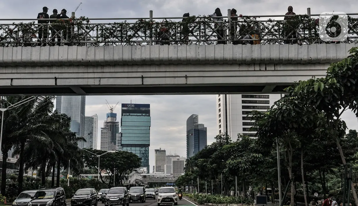 Kendaraan melintas di bawah JPO tanpa atap di kawasan Sudirman, Jakarta, Minggu (4/4/2021). JPO tanpa atap masih menjadi wisata alternatif warga ibu kota dalam menghabiskan waktu akhir pekan untuk berfoto-foto dengan latar belakang gedung perkantoran. (merdeka.com/Iqbal S Nugorho)