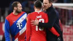 Pelatih Julian Nagelsmann (kanan) merayakan dengan gelandang Bayern Munchen Leroy Sane setelah babak 16 besar Liga Champions UEFA, pertandingan leg kedua melawan Paris Saint-Germain FC di Munich, Jerman selatan, pada 8 Maret 2023. CEO Bayern Munchen yakni Oliver Kahn mengatakan bahwa keputusan klub mengganti Julian Nagelsmann dengan Thomas Tuchel sebagai pelatih ada alasannya. (FRANCK FIFE/AFP)