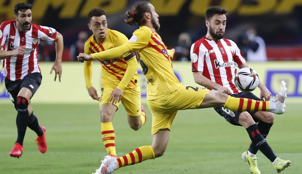 Pemain Barcelona, Oscar Mingueza, berebut bola dengan pemain Athletic Bilbao, Unai Lopez, pada laga final Copa del Rey di Stadion Olimpico de Sevilla, Minggu (18/4/2021). Barcelona menang 4-0 atas Athletic Bilbao. (AP Photo/Angel Fernandez)