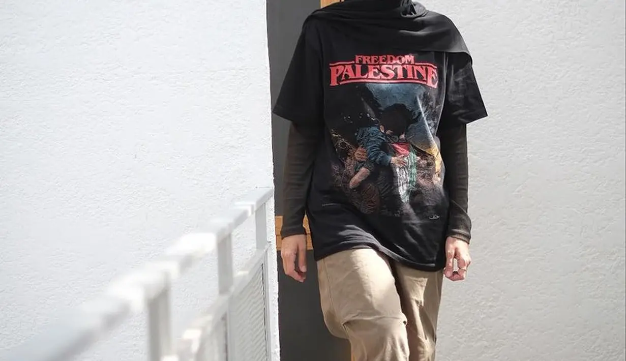 Tak hanya satu, Zaskia pun mengenakan tshirt hitam dengan tulisan Freedom Palestine lengkap dengan gambar seorang laki-laki memeluk seorang anak. Kaos tersebut dipadukan kerudung hitam, manset, dan celana coklat bahan. [@zaskiadyamecca]