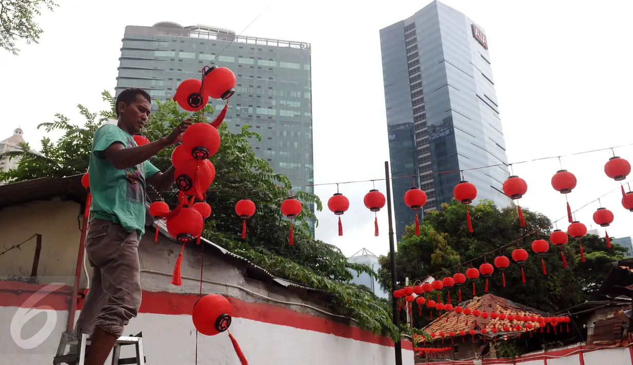 Pekerja memasang lampion di Vihara Amurva Bhumi, Jakarta, Minggu (31/1/2016). Pemasangan lampion jelang perayaan Tahun Baru Imlek 2567 merupakan simbol pengharapan keberkatan dan keberuntungan di tahun mendatang. (Liputan6.com/Helmi Fithriansyah)