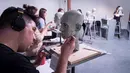Siswa menyelesaikan bagian mulut patung wajah orang mati dari tanah liat di New York, AS pada  bulan Januari 2016. Patung dibuat dengan harapan dapat menemukan identitas orang yang mati. (Courtesy the New York Academy of Art/Handout via REUTERS)