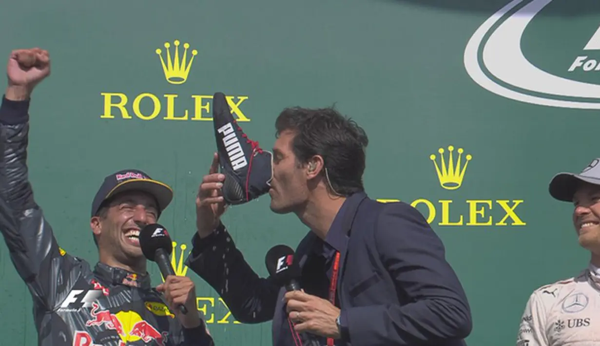 Mantan pebalap F1 asal Australia, Mark Webber, meminum sampanye dari sepatu Daniel Ricciardo sebelum mewawancarai para juara di podium F1 GP Belgia di Sirkuit Spa-Francorchamps, Minggu (28/8/2016). (Bola.com/Twitter/F1)