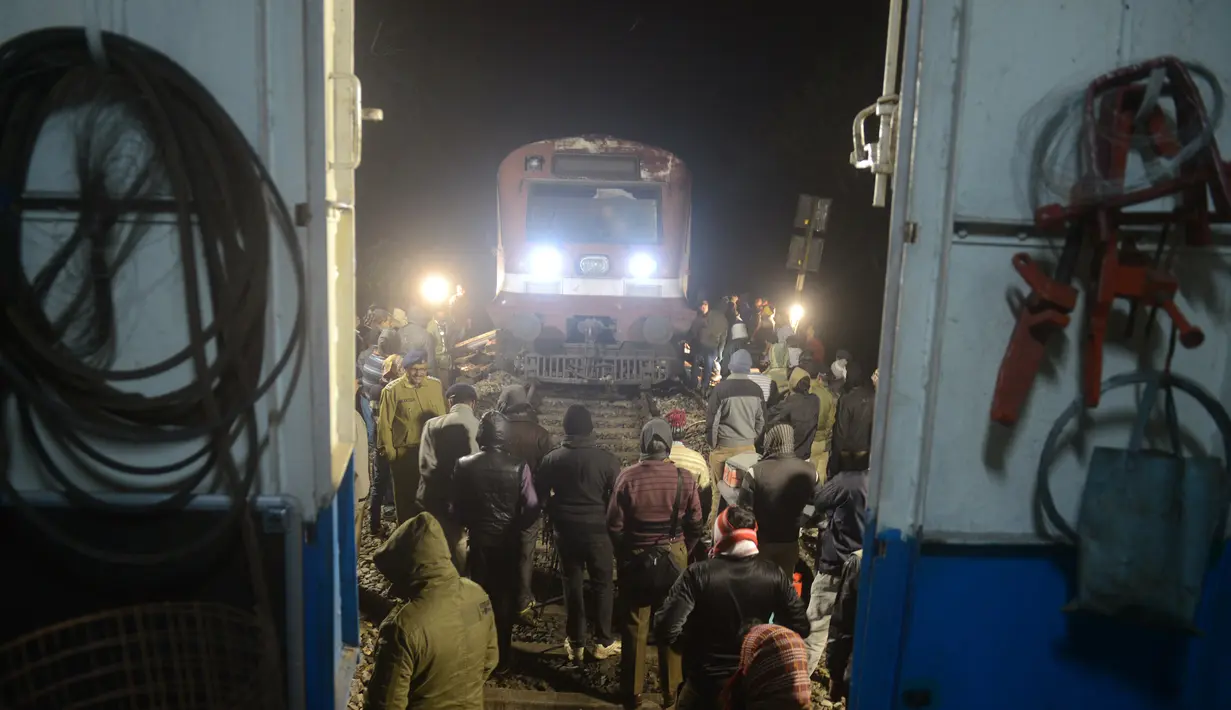 Personil kereta api India bekerja untuk memulihkan layanan kereta penumpang yang tergelincir setelah bertabrakan dengan gajah betina di daerah suaka margasatwa Mahananda, sekitar 30 km dari Siliguri, India, Selasa (15/12). (AFP PHOTO/Diptendu Dutta)