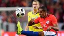 Bek Chile, Jean Beausejour berusaha membuang bola dari kawalan gelandang Swedia, Viktor Claesson saat bertanding pada pertandingan persahabatan internasional Friends di Arena, Stockholm, (24/3). Chile menang 2-1 atas Swedia. (Anders Wiklund/TT via AP)