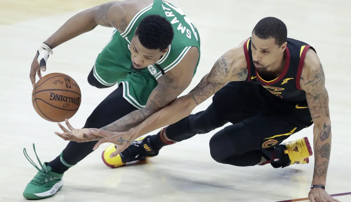 Pemain Boston Celtics, Marcus Smart (kiri) mencoba melewati pemain Cleveland, George Hill pada gim keempat final Wilayah Timur NBA basketball di Quicken Loans Arena (21/5/2018). Cavaliers menang 111-102. (AP/Tony Dejak)