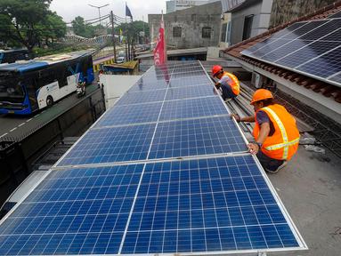 Teknisi Green Energy Nusantara Mandiri memasang PLTS Hybrid 6210 Wp battery 4,8 kwhpada atap rumah kantor di kawasan Manggarai Jakarta, Jumat (29/12/2023). (merdeka.com/Arie Basuki)
