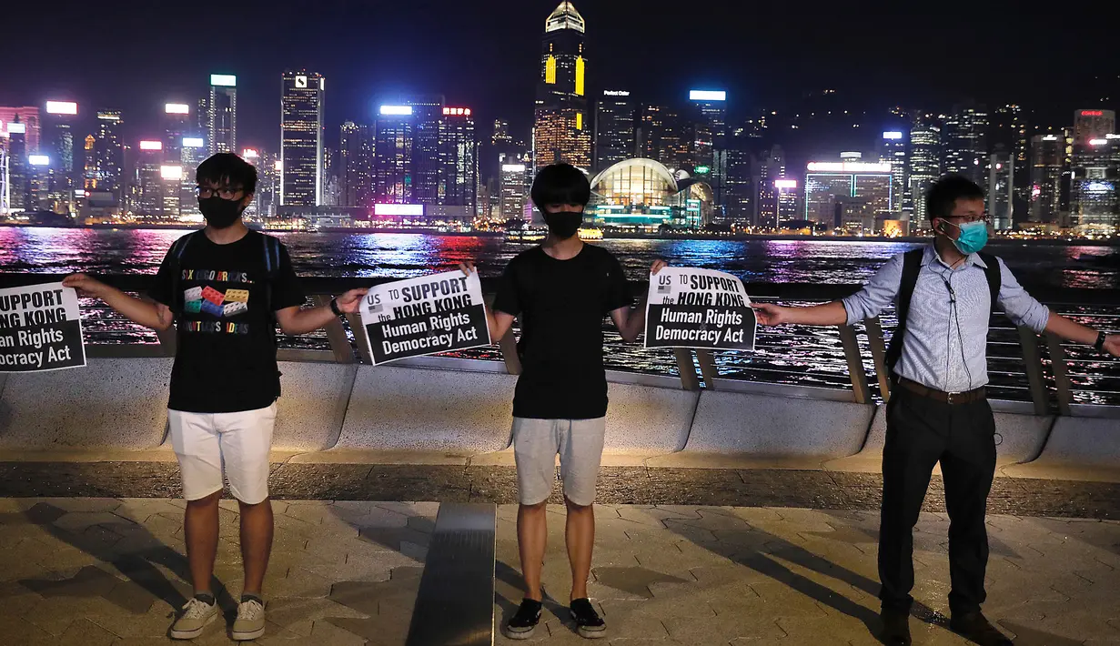 Demonstran prodemokrasi membentuk rantai manusia di tepi pantai Tsim Sha Tsui, Hong Kong, Jumat (23/8/2019). Tua, muda, dan pekerja kantor berjas ikut serta dalam aksi tersebut. (AP Photo/Vincent Yu)