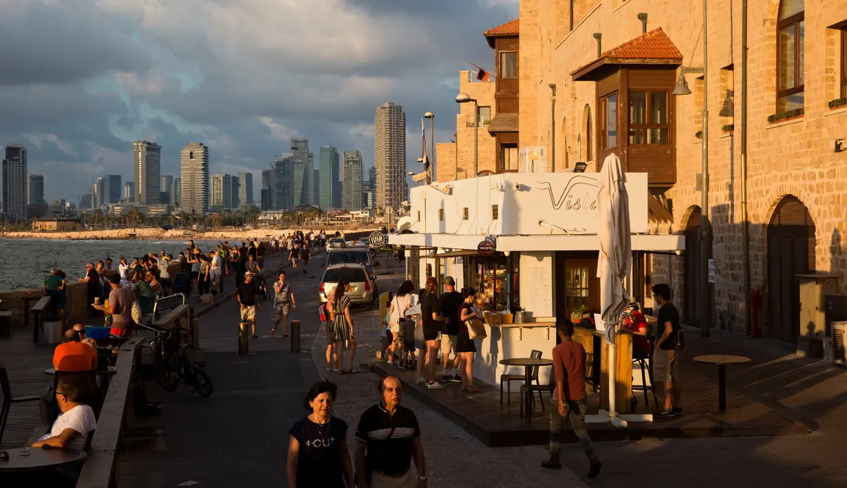 Orang-orang menikmati suasana di Pelabuhan Jaffa, Israel, 21 Juli 2018. Pelabuhan Jaffa adalah tempat kuno dibagian selatan Tel Aviv, Israel yang menghadap ke Laut Mediterania. (AP Photo/Oded Balilty)