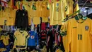 Seorang pria melihat kaus tim sepak bola nasional Brasil yang dipajang di pasar Saara, Rio de Janeiro, Brasil, pada Selasa 9 Juni 2026, menjelang turnamen Piala Dunia FIFA 2026. (Nelson ALMEIDA/AFP)