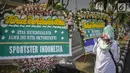 Warga melintas dekat karangan bunga atas meninggalnya istri Indro Warkop, Nita Octobijanthy yang terpajang di rumah duka kawasan Pulo Mas, Jakarta, Rabu (10/10). Istri Indro Warkop meninggal di usia 59 tahun akibat kanker. (Liputan6.com/Faizal Fanani)