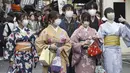 Sejumlah perempuan berpakaian tradisional kimono berjalan di sepanjang tujuan wisata di Kyoto, Jepang barat, Senin (13/3/2023). Meski aturan penggunaan masker telah dilonggarkan,  banyak orang di tempat-tempat umum dan tempat berkumpul yang masih menggunakan masker. (Kyodo News via AP)