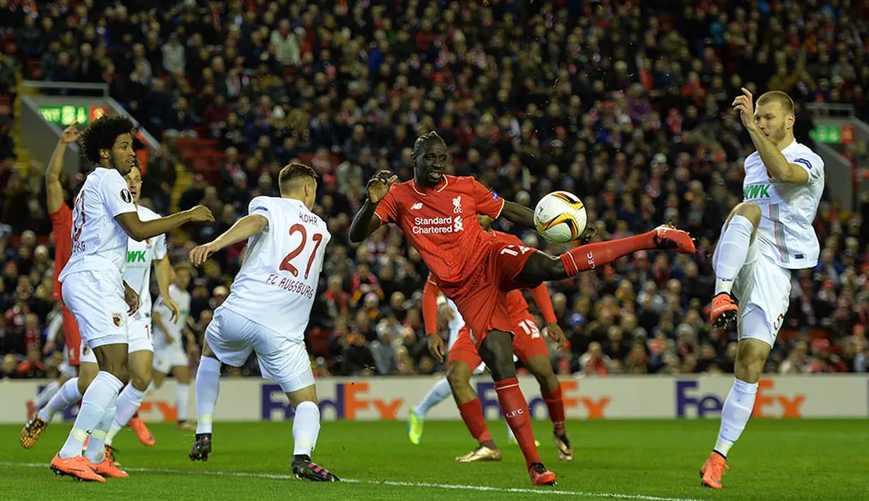 Bek Liverpool, Mamadou Sakho, berusaha melewati pemain Augsburg, Ragnar Klavan. Gol kemenangan Liverpool tercipta pada menit ke-5 melalui penalti James Milner. (EPA/Peter Powell)