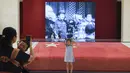 Seorang gadis berpose di depan bendera nasional Tiongkok yang dikibarkan pada 1 Oktober 1949 di Museum Nasional China di Beijing (22/8/2019). Museum Nasional Tiongkok memiliki empat lantai berisi aneka dokumen sejarah peradaban dan kisah perjuangan politik Tiongkok. (AFP Photo/Wang Zhao)