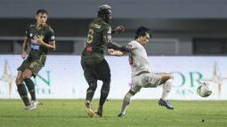 Gelandang Tira Persikabo, Essengue Parfait, menarik baju gelandang Persela Lamongan, Kei Hirose, pada laga Liga 1 di Stadion Pakansari, Bogor, Senin (16/12). Kedua klub bermain imbang 1-1. (Bola.com/Vitalis Yogi Trisna)