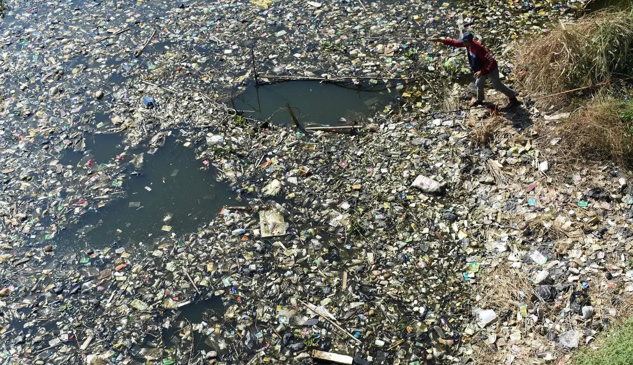 Warga mencari sampah plastik untuk didaur ulang di aliran Sungai Citarum, Bandung, Jawa Barat, Rabu (26/6/2019). Berbagai upaya dilakukan pemerintah untuk membersihkan sungai yang menyandang predikat salah satu tempat paling tercemar di dunia ini. (Timur Matahari/AFP)