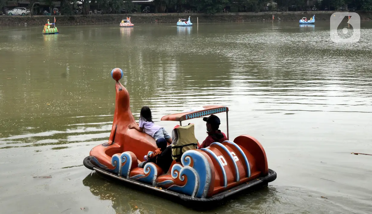 Warga berkeliling dengan menggunakan perahu wisata di Setu Babakan, Jagakarsa, Jakarta Selatan, Minggu (4/4/2021). Setu Babakan kembali dibuka untuk umum pada 27 Maret 2021 dengan menerapkan protokol kesehatan. (merdeka.com/Arie Basuki)