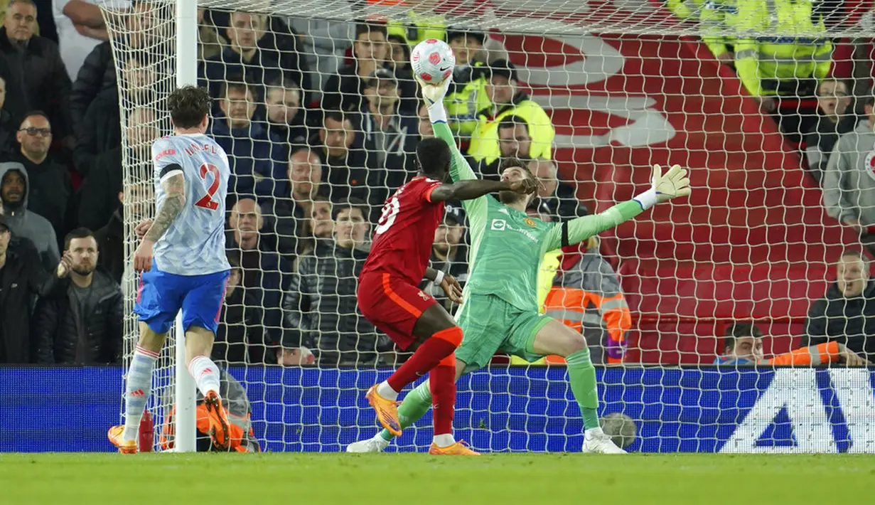 Penjaga gawang Manchester United David de Gea (kanan) melakukan penyelamatan di depan pemain Liverpool Sadio Mane pada pertandingan sepak bola Liga Inggris di Stadion Anfield, Liverpool, Inggris, 19 April 2022. Liverpool menang 4-0. (AP Photo/Jon Super)
