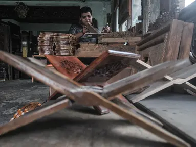 Pekerja menyelesaikan pembuatan rehal atau meja untuk Al-qur’an di Toko Mabruri 12, Klender, Jakarta, Rabu (13/4/2022). Penjualan rehal pada Ramadhan kali ini mengalami peningkatan hingga 50 persen dibandingkan tahun sebelumnya. (merdeka.com/Iqbal S Nugroho)