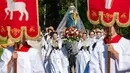 Sejumlah remaja wanita mengenakan pakaian tradisional Sorbs memikul patung Bunda Maria saat mengikuti prosesi Whit Monday di gereja di Rosenthal, Jerman (21/5). Prosesi ini digelar usai tujuh minggu dari perayaan Paskah. (AP Photo / Jens Meyer)