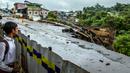Seorang anak laki-laki melihat lokasi longsor akibat hujan deras di kawasan Caringin, Bogor, Jawa Barat, Kamis (2/32023). Longsor mengakibatkan jalan nasional yang menghubungkan Bogor dan Sukabumi itu hanya dapat dilalui satu lajur kendaraan. (ADITYA AJI/AFP)