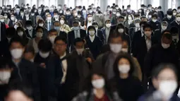 Lorong stasiun penuh dengan penumpang yang memakai masker di Tokyo, Jepang, 27 April 2020. Banyak warga Jepang yang masih pergi bekerja dengan menggunakan kereta walaupun ada risiko tertular virus corona COVID-19. (AP Photo/Eugene Hoshiko, File)