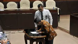 Adhar Hakim menandatangani persetujuan saat mengikuti Fit & Proper Test dengan Komisi II DPR untuk menjadi pimpinan Ombudsman RI di Gedung DPR RI, Jakarta, Selasa (26/1/2016). Adhar merupakan kepala perwakilan Ombudsman di NTB. (Liputan6.com/Johan Tallo)