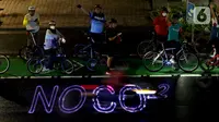 Pegiat bersepeda dan aktivis pecinta lingkungan saat aksi gowes Kelap Kelip Jakarta Night Ride #NOP26 di Jalan Jenderal Sudirman, Jakarta, Jumat (26/11/2021). Aksi ini mendorong pemimpin dunia berkomitmen meningkatkan tingkat bersepeda untuk mengurangi emisi karbon. (Liputan6.com/Helmi Fithriansyah)