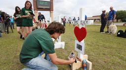 Siswa SMA Santa Fe, dan masyarakat memperingati Moment of Silence di sekolah mereka di Texas, AS, Senin (21/5). Gubernur Texas Greg Abbott menyerukan untuk mengheningkan cipta untuk korban penembakan Texas. (Steve Gonzales/Houston Chronicle via AP)
