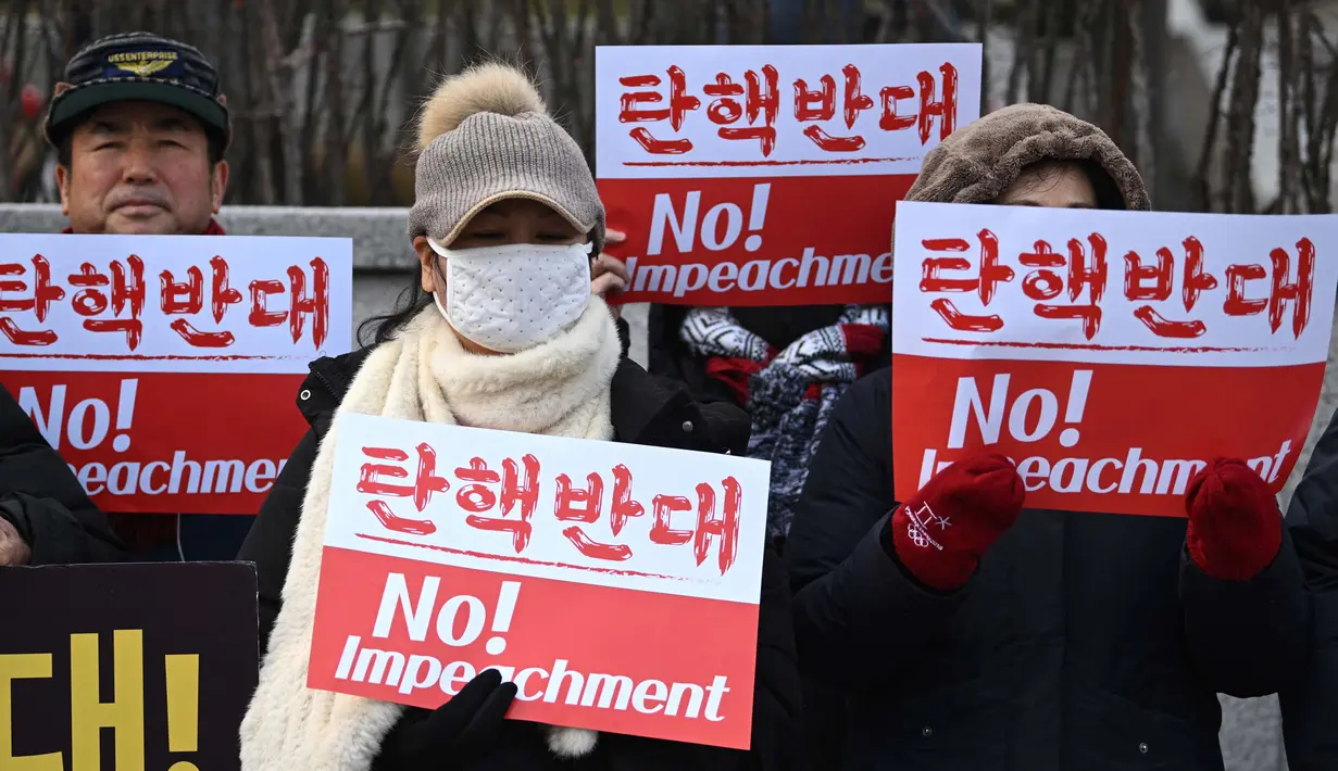 Para pendukung Presiden Korea Selatan yang dimakzulkan, Yoon Suk Yeol, memegang plakat bertuliskan “Tidak Ada Pemakzulan!” di depan Mahkamah Konstitusi di Seoul pada tanggal Selasa 14 Januari 2025. (Jung Yeon-je/AFP)