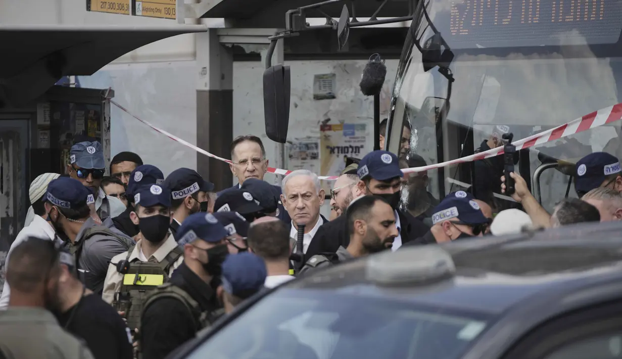 Perdana Menteri Israel Benjamin Netanyahu (tengah) meninjau langsung lokasi serangan penembakan, di mana beberapa orang tewas dan lainnya luka-luka di sebuah halte bus di Yerusalem, Senin, 8 September 2025. (AP Photo/Mahmoud Illean)