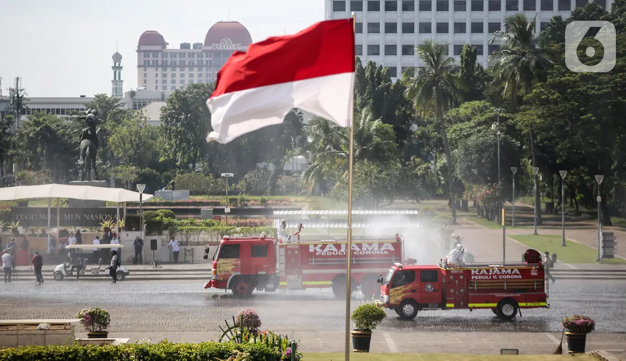 Petugas Pemadam Kebakaran menyemprotkan cairan disinfektan di lingkungan Monas, Jakarta, Rabu (17/6/2020). Penyemprotan dilakukan untuk mencegah penyebaran COVID-19 dalam rangka persiapan pembukaan kembali Monumen Nasional (Monas) pada Sabtu, 20 Juni 2020.  (Liputan6.com/Faizal Fanani)