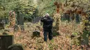 Pemburu hantu "Paranormal Investigator" menelusuri batu nisan saat mencari aktivitas gaib di pusat pemakaman tua di Wina, Austria, 20 Oktober 2016. Pemakaman ini disinyalir memiliki aura mistis yang kental dengan aktivitas makhluk halus. (JOE KLAMAR/AFP)