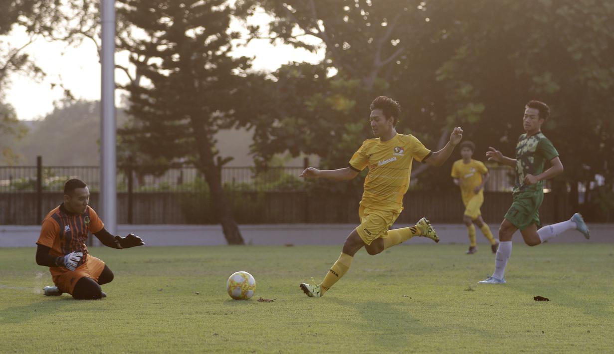 Striker Vamos Indonesia, Dony, berduel dengan kiper PS Tira Persikabo U-18 pada pertandingan persahabatan di Lapangan A GBK, Jakarta, Rabu (29/5). Kedua klub bermain imbang 1-1. (Bola.com/Yoppy Renato)