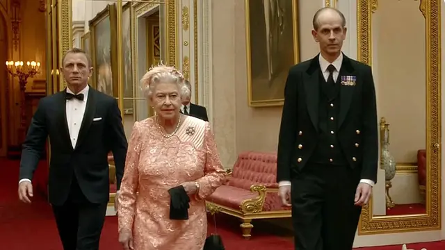 Ratu Elizabeth dan karakter James Bond yang diperankan oleh Daniel Craig berjalan di sepanjang koridor Istana Buckingham dalam film pendek untuk Olimpiade London 2012. (Foto: AFP)