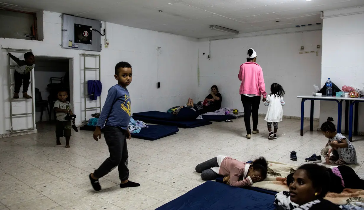 Warga berlindung dari serangan roket di shelter bom Kota Ashkelon, Israel, Rabu (13/11/2019). Militan Palestina menghujani Israel dengan roket sebagai balasan atas tewasnya komandan Jihad Islam Palestina Baha Abu Al-Ata dalam serangan udara Israel. (AP Photo/Tsafrir Abayov)