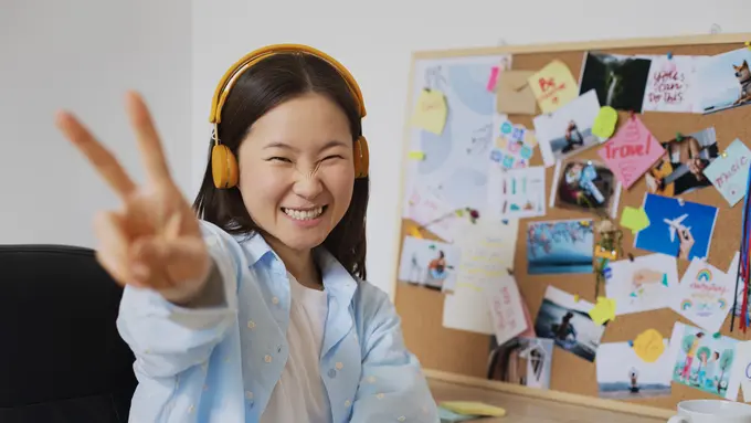 Seorang perempuan sedang berpose sambil mengenakan headphone (Foto Dok: Freepik/freepik)