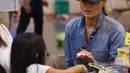 Ibu Negara AS, Melania Trump berbincang dengan seorang anak korban Badai Harvey di NRG Center di Houston (2/9). (AFP Photo/Nicholas Kamm)