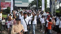 Peserta eserta berjalan menuju bus mudik gratis di depan Kantor PT ASABRI, Jakarta, Minggu (10/6). Program mudik gratis ini merupakan edisi perdana PT ASABRI. (Merdeka.com/Iqbal S. Nugroho)